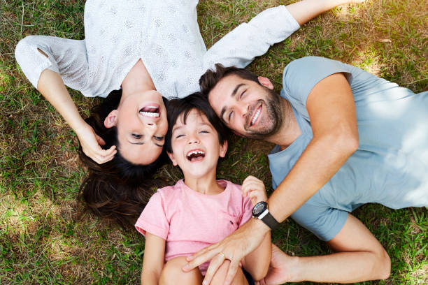 Family smiling Family smiling together in park looking down photos stock pictures, royalty-free photos & images