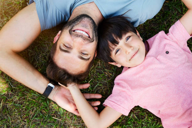 father and son - offspring child lying on back parent imagens e fotografias de stock