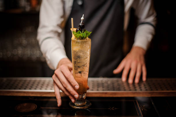 istock Bartender holding a glass with fresh and sweet summer cocktail 1012429666
