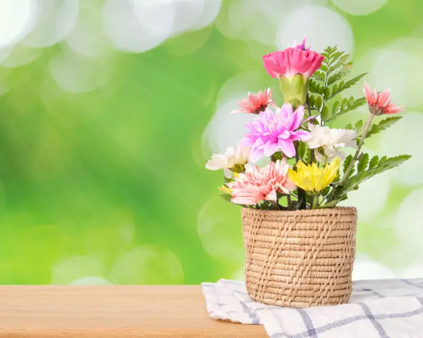 Flowers in wood basket on green natural background., With copy space.
