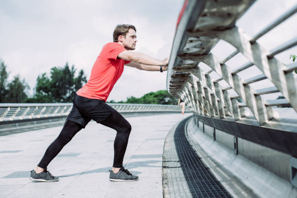 istock Serious Man Stretching Calf and Leaning on Railing 1012442040