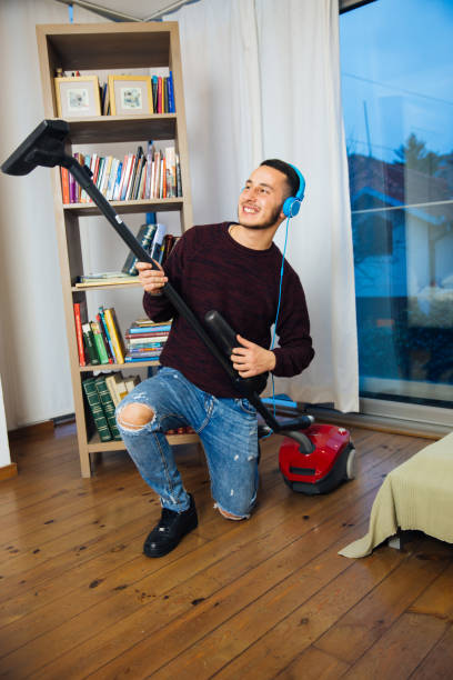istock Musical Man Cleaning The House And Enjoying 1012460362