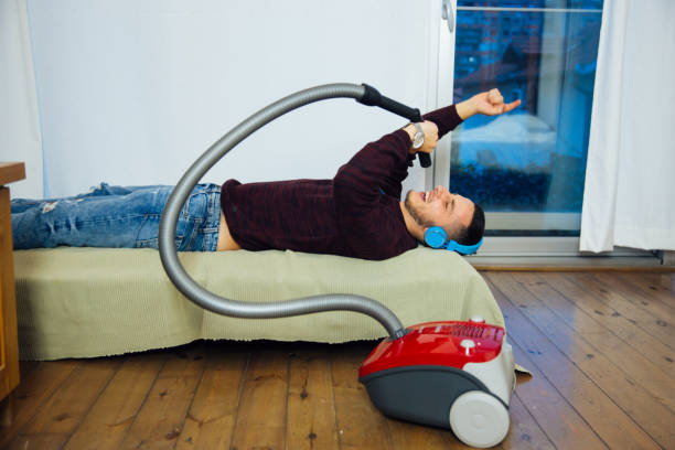istock Musical Man Cleaning The House And Enjoying 1012460424
