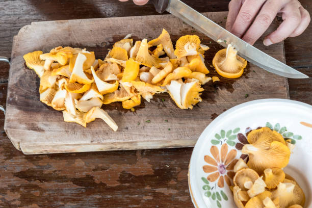 istock Slicing Chanterelle Mushrooms On Wooden Chopping Board 1012465548