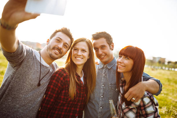 istock friends toasting beer at the park and take a selfie 1012467174