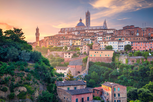 Cityscape aerial image of medieval city of Siena, Italy during sunrise.