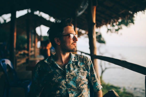 jeune homme détente sur la plage de l’île de koh lanta, thaïlande - rural watch photos et images de collection