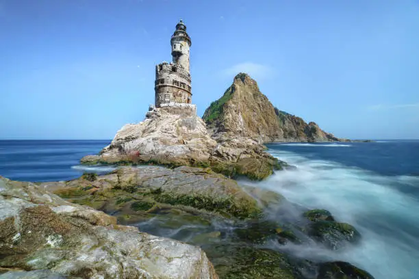 Abandoned Japanese lighthouse on the rock in the south of Sakhalin Island, Russia.