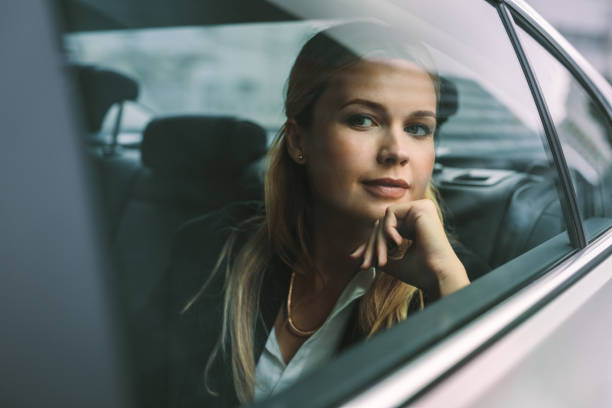 istock Female executive travelling by a car 1012475810