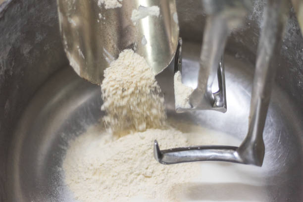istock Loading flour into an industrial dough mixer. Close up view. 1012496834