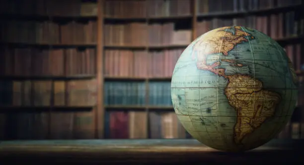 Photo of Old globe on bookshelf background.