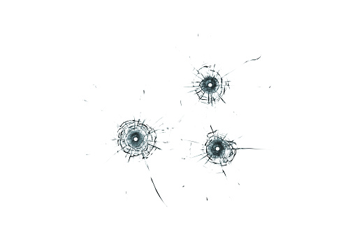 Broken glass triple bullet holes in glass isolated on white background