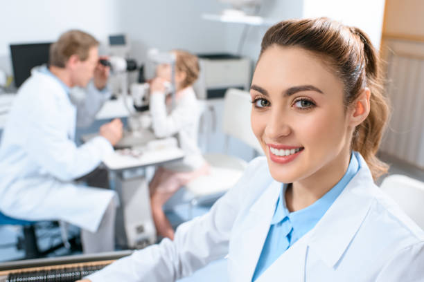 istock smiling ophthalmologist holding lenses for trial frame while colleague examining kid with visual field test 1012509772