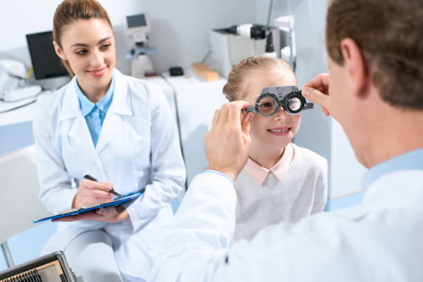 istock ophthalmologists examining kid eyes with trial frame and writing diagnosis 1012509866