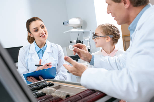 istock optometrists examining child eyes with trial frame and writing diagnosis 1012509888