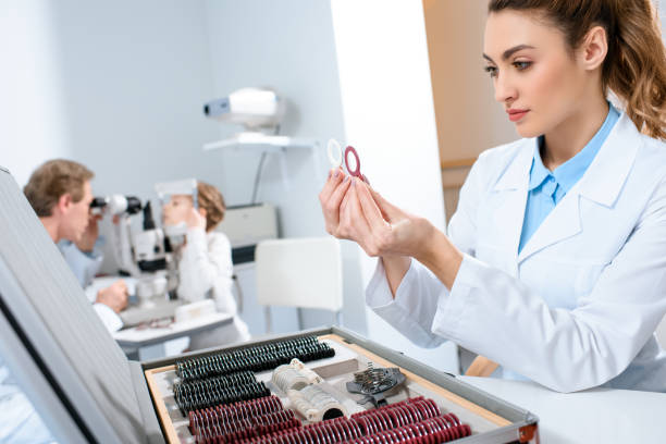 istock female optometrist holding lenses for trial frame while colleague examining kid with visual field test 1012509908