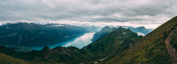 panoramic view from the peak of mountain to a blue lake covered in clouds, brienzer rothorn switzerland alps - brienz interlaken switzerland rural scene imagens e fotografias de stock