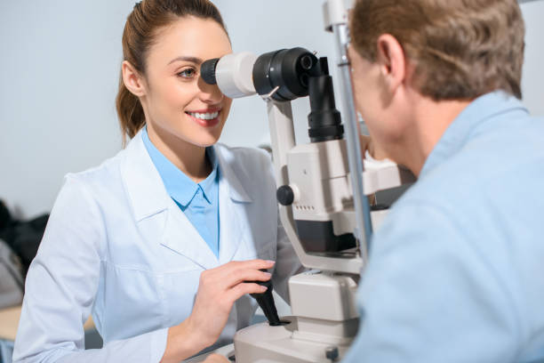 istock professional optician examining man with modern optical equipment 1012512868