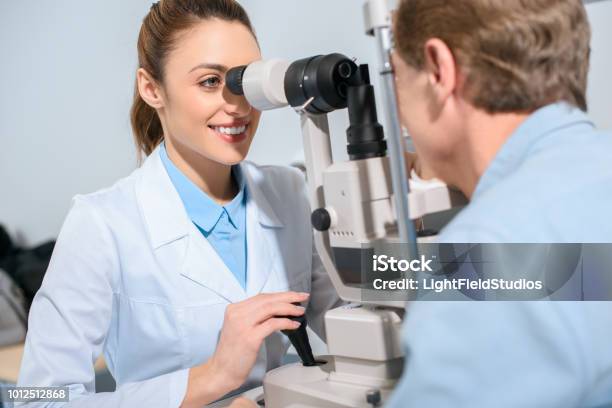 Professional Optician Examining Man With Modern Optical Equipment Stock Photo - Download Image Now