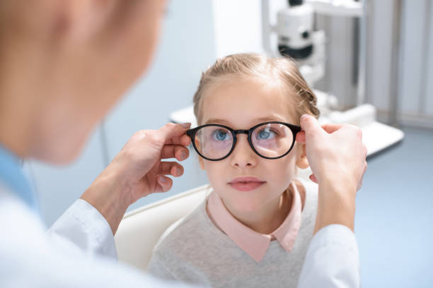 optiker und geißlein in gläsern in der optik - child glasses eyewear little girls stock-fotos und bilder