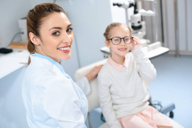 istock smiling ophthalmologist and kid in eyeglasses in optics 1012513124