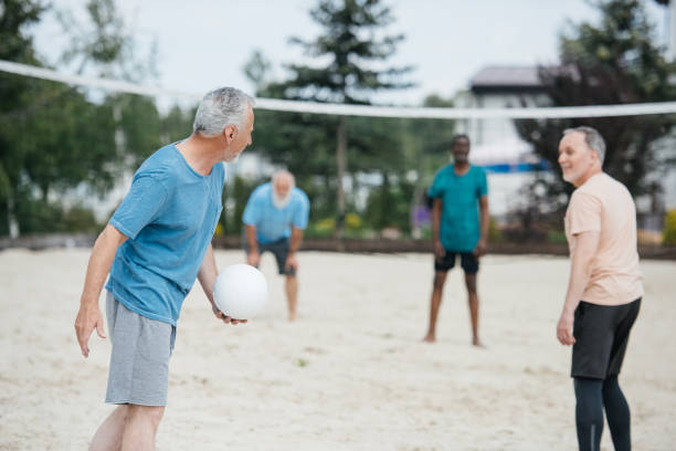 istock selective focus of multicultural old friends playing volleyball on beach on summer day 1012513552