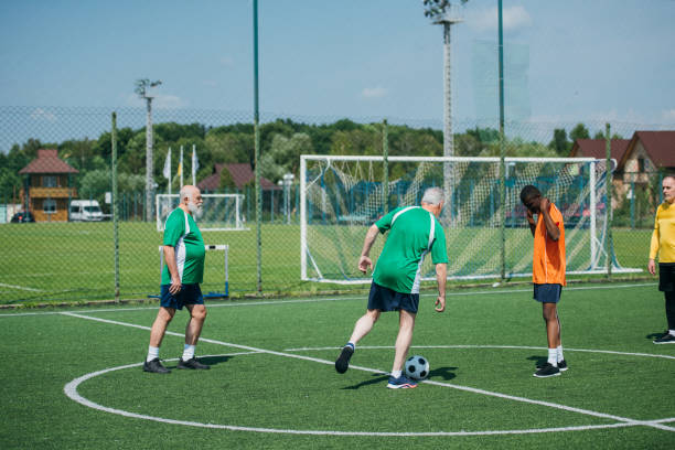 istock multicultural elderly friends playing football together 1012522166