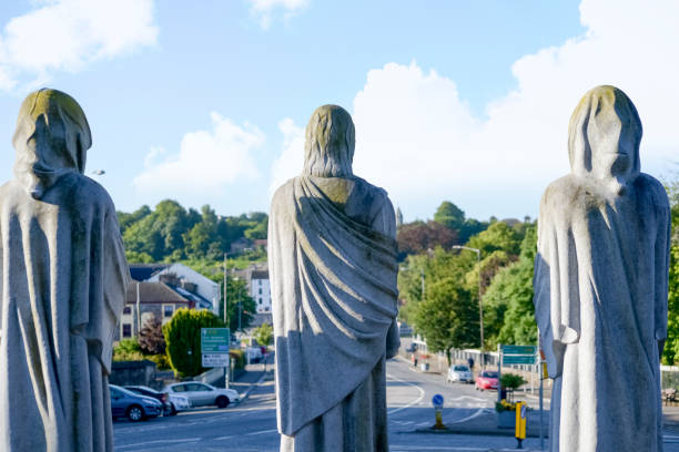 three faceless monk statues outside church stock photo