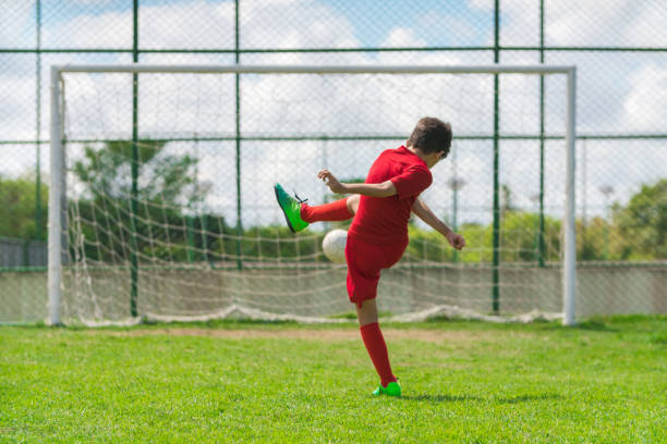 istock Boy playing soccer on court 1012523308