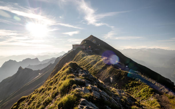 sunflares の山の尾根、スイス アルプスの山脈を望む山の頂上での日の出 - brienz house switzerland european alps ストックフォトと画像