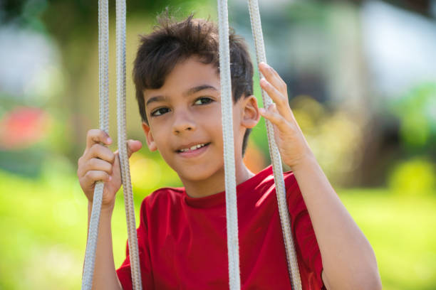 istock Happy boy on swing in public park 1012526526
