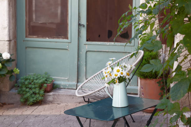 istock French patio table with rustic jug of daisies 1012527864