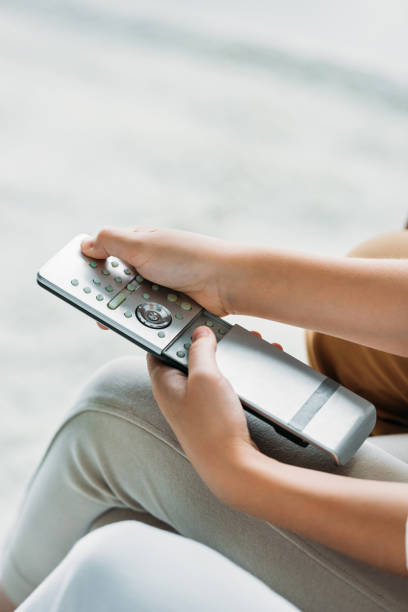 istock cropped shot of child pressing button on tv remote control 1012530308