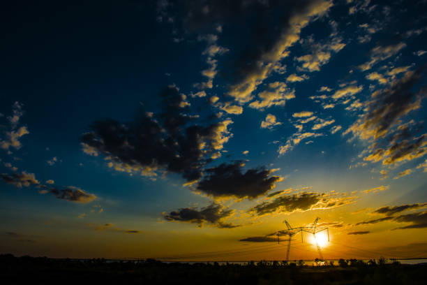 istock 750 kV line support against a beautiful sunset 1012530522