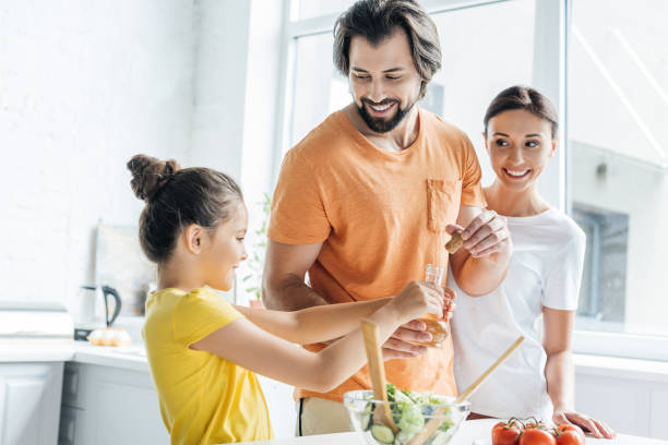 istock happy young family cooking together and having fun at kitchen 1012531648