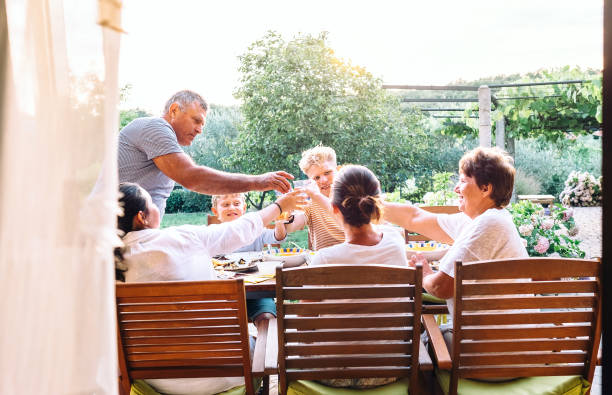 istock Three generations one family  have dinner in summer garden 1012535472