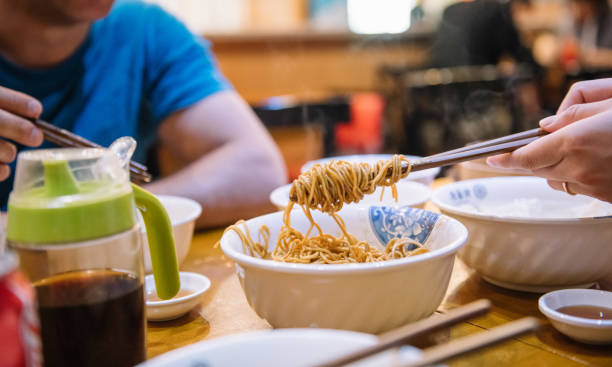 istock eating chinese noodles with chopsticks 1012539070