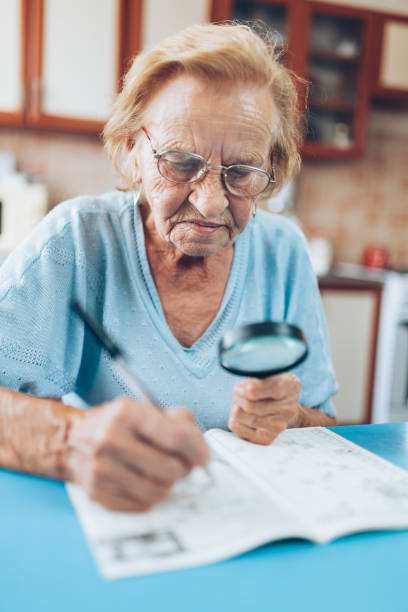 istock Senior woman enjoys solving a crossword puzzle 1012558340