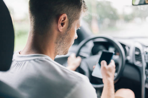 conductor imprudente mediante un teléfono móvil mientras conduce - driving text messaging accident car fotografías e imágenes de stock