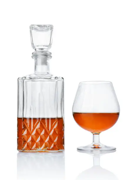 Photo of Strong alcoholic drink cognac in sniffer glass and crystal decanter