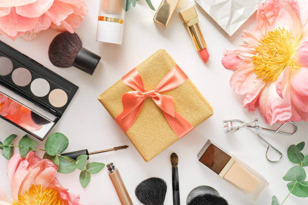 set of decorative cosmetics and present on white table