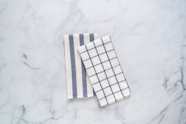 istock New kitchen towels with simple blue pattern folded on marble counter. 1012574102