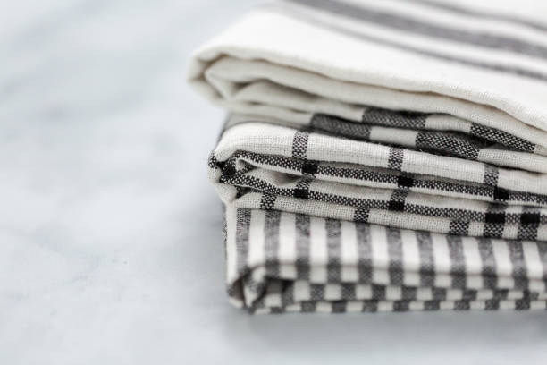 istock New kitchen towels with simple black pattern folded on marble counter. 1012574148