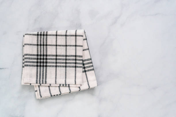 istock New kitchen towels with simple black pattern folded on marble counter. 1012574180