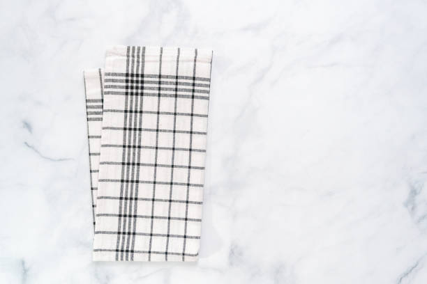 istock New kitchen towels with simple black pattern folded on marble counter. 1012574186