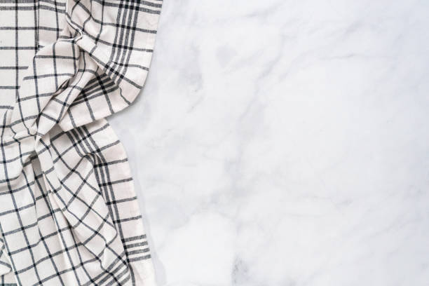 istock New kitchen towels with simple black pattern folded on marble counter. 1012574188
