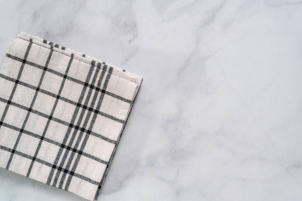 istock New kitchen towels with simple black pattern folded on marble counter. 1012574194