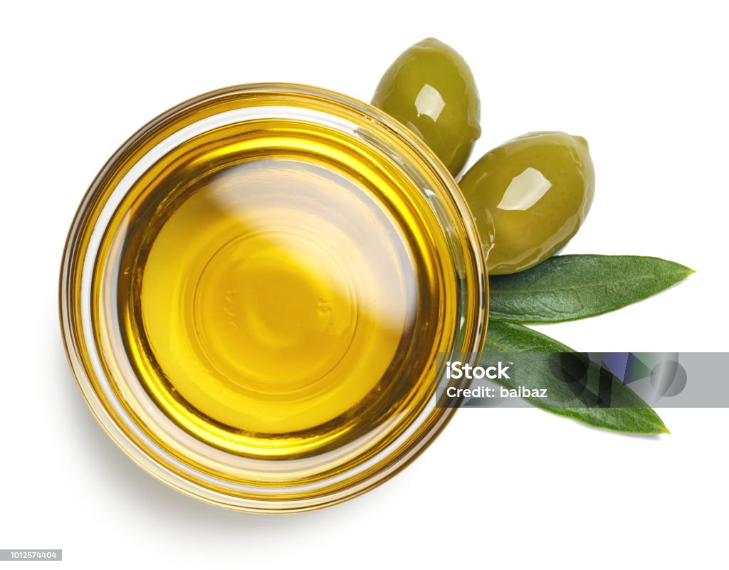 Bowl of olive oil and green olives with leaves Bowl of fresh extra virgin olive oil and green olives with leaves isolated on white background. Top view Cooking Oil Stock Photo