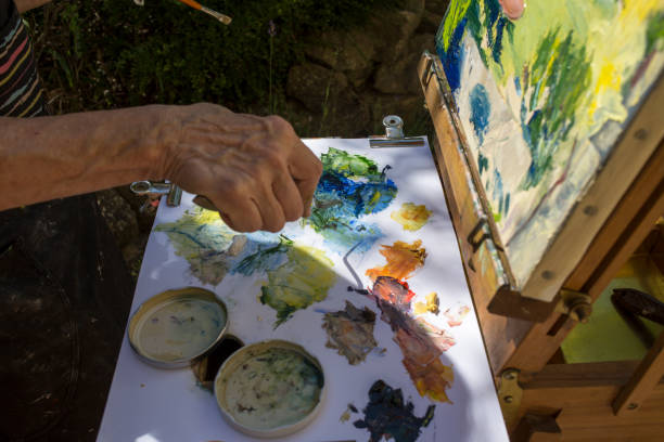 istock Senior's hand, painting with oils 1012580598