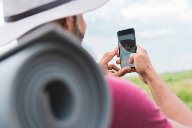 istock hiker with backpack and tourist mat taking selfie on smartphone 1012587230
